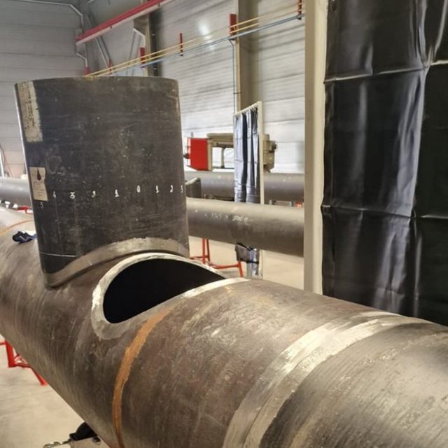 Gabarito de traçado com as ordenadas marcadas, encostado à abertura de ramal já cortada no tubo